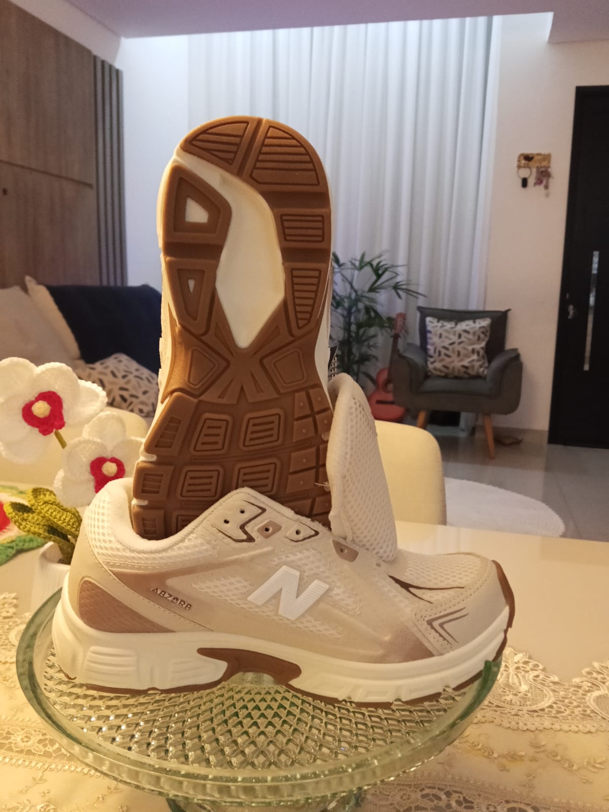 Tênis New Balance branco e bege com solado em exibição